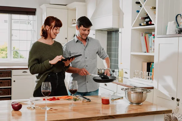 Tudo tem de parecer perfeito para o nosso blog. Tiro de um casal usando um tablet digital enquanto cozinha em casa. — Fotografia de Stock