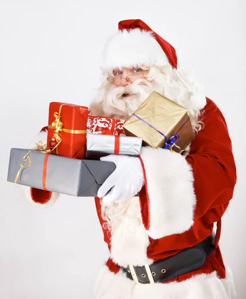 クリスマスの魔法を持ってきて。サンタクロースはクリスマスの贈り物を包んだ山を保持-肖像画. — ストック写真