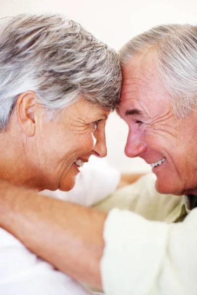 Couple d'âge mûr souriant se regardant. Gros plan de couple mature affectueux souriant tout en se regardant, tête à tête. — Photo