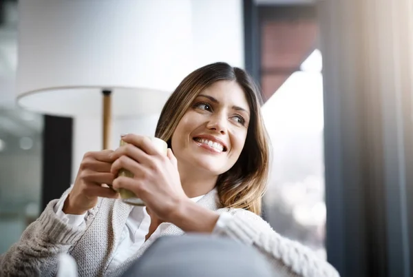 Один глоток кофе это все, что нужно.... Обрезанный снимок молодой женщины, наслаждающейся чашкой кофе, расслабляясь дома. — стоковое фото