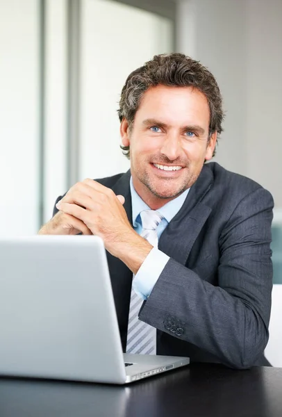 En leende affärsman som använder laptop. Porträtt av affärsman som använder laptop och ger dig ett varmt leende. — Stockfoto