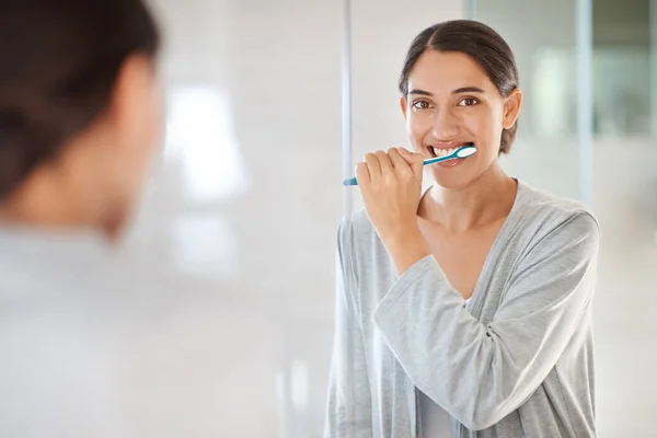 Піклуючись про її посмішку. Молода жінка чистить зуби . — стокове фото