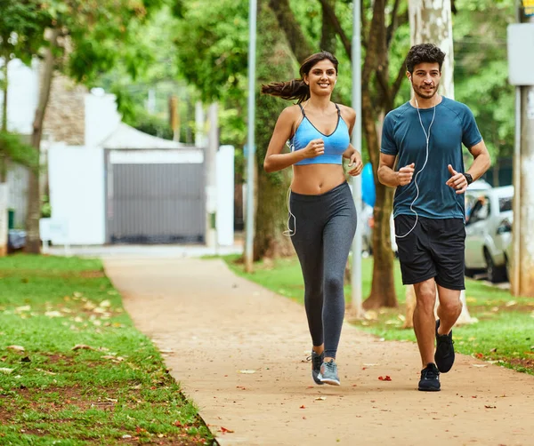 En el camino hacia la conquista de sus objetivos de fitness. Tiro de una joven pareja deportiva haciendo ejercicio juntos al aire libre. — Foto de Stock