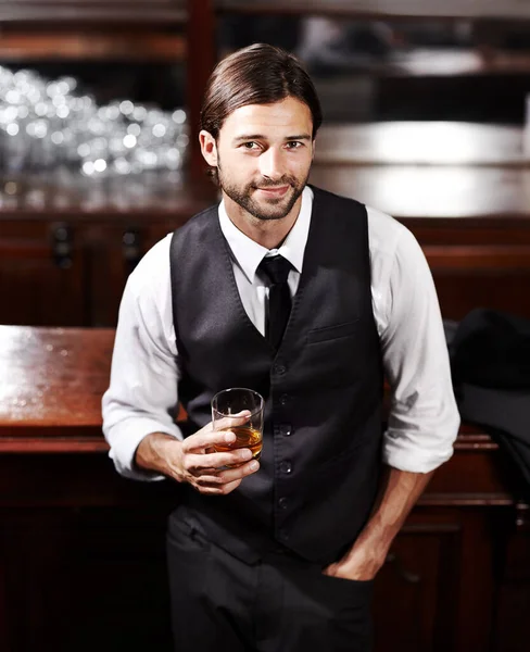 Sólo tomándolo con calma. Retrato de un joven bien vestido sentado en un bar con una bebida. —  Fotos de Stock