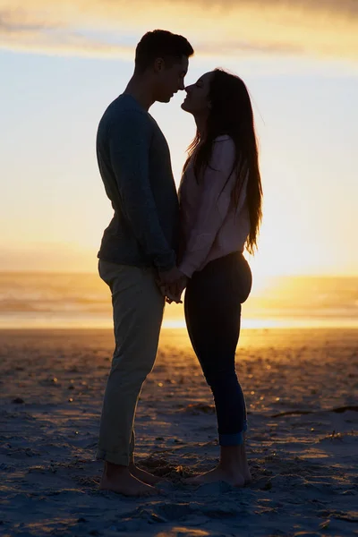 Tu n'es rien de moins que mon tout. Plan en silhouette d'un jeune couple sur la plage. — Photo