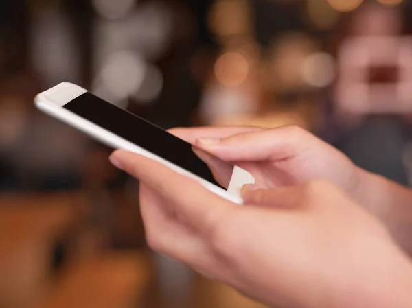 Mantenha-se em contacto. Tiro cortado de uma mulher irreconhecível usando seu celular em um café. — Fotografia de Stock