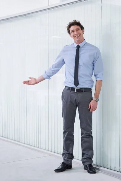 事務所へようこそ。彼の腕でジェスチャー若いビジネスマンの完全な長距離ショット. — ストック写真
