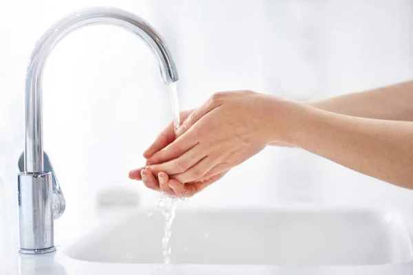 Mantener las manos limpias. Tiros de manos lavadas con un grifo. — Foto de Stock