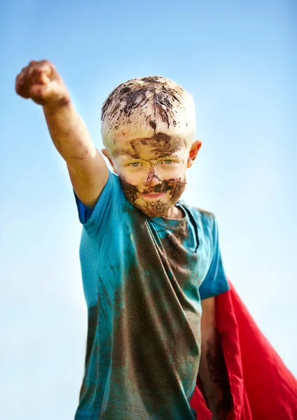 Ein schlammiger Superheld. Ein kleiner Junge als Superheld verkleidet und mit Schlamm bedeckt. — Stockfoto