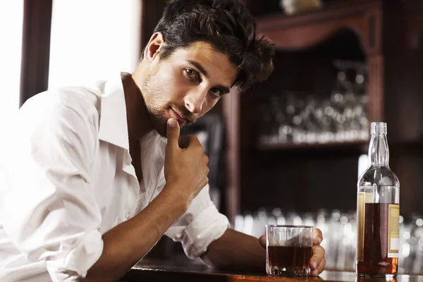Reunir pensamientos después de un día agitado. Joven hombre sofisticado bebiendo whisky solo en el bar. —  Fotos de Stock