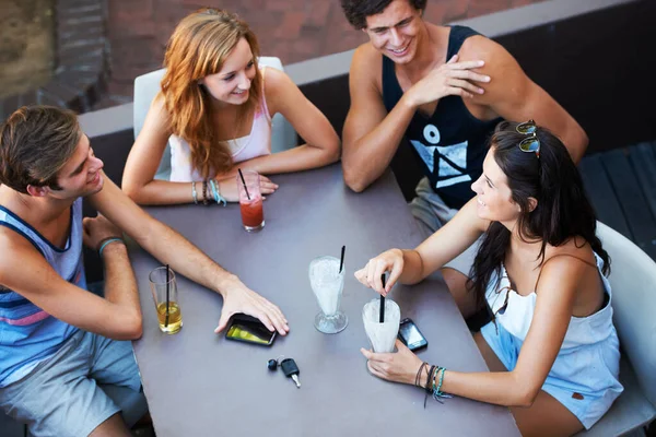 Розслабся з усією бандою. Група підлітків насолоджується молочними коктейлями та напоями під час перебування у відкритому ресторані - високий кут . — стокове фото
