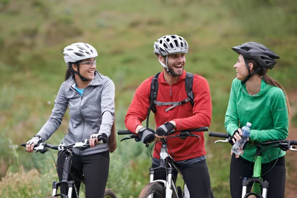 笑いを共有するために時間がかかる。自転車と一緒に歩道に立っている若いサイクリストのグループ. — ストック写真