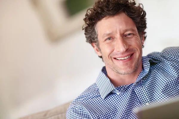 Korzystam z wygody domu. Portret szczęśliwego mężczyzny używającego tabletu w domu. — Zdjęcie stockowe