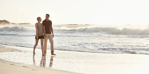 A fazer um passeio ao pôr-do-sol. Um casal amoroso na praia. — Fotografia de Stock