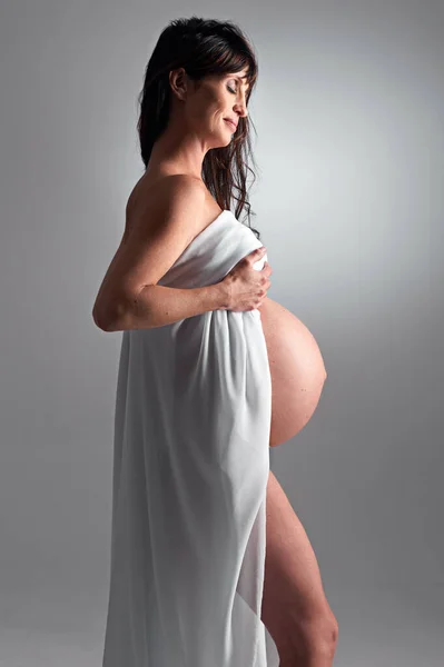 A aguardar a sua chegada em breve. Uma mulher grávida segurando sua barriga. — Fotografia de Stock