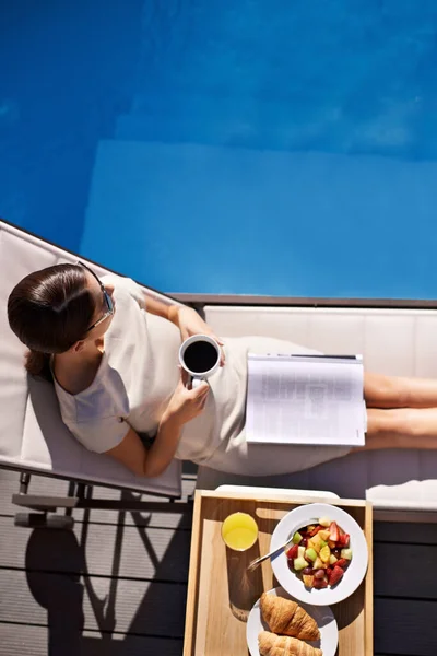Lüks manzaralı. Çekici bir genç kadının havuz başında kahvaltısının keyfini çıkarmasının en iyi görüntüsü.. — Stok fotoğraf