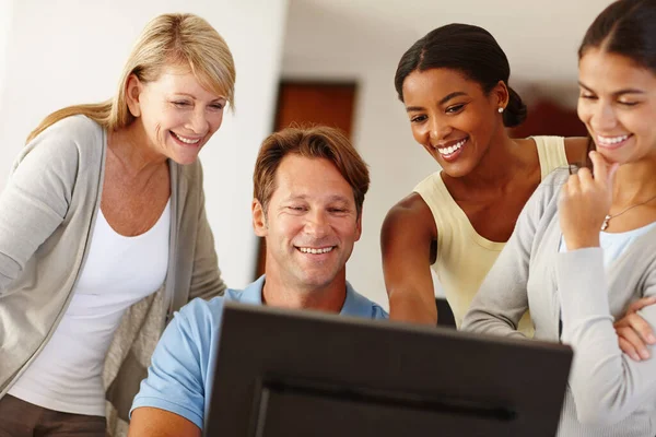 Taking pride in their work together. Shot of a work team gathered around a computer. — Stock Photo, Image