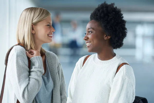 Ze zijn goede vrienden. Twee jonge studenten die samen staan en naar elkaar lachen. — Stockfoto