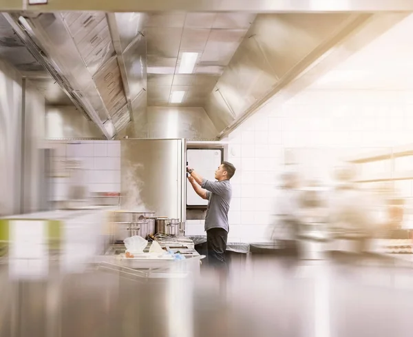 Hans kök är en väloljad maskin. Beskuren bild av en ung manlig kock som lagar mat i sitt kök. — Stockfoto