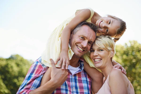 Familie is een geschenk. Een bijgesneden portret van twee gelukkige ouders met hun jonge dochter buiten staan. — Stockfoto
