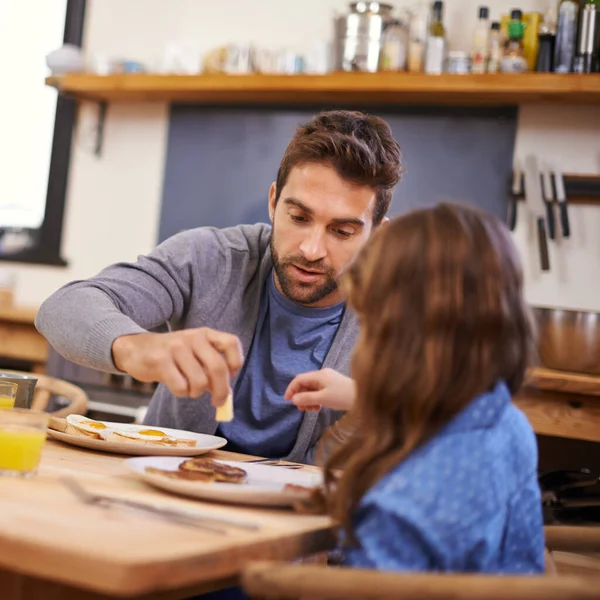 Начиная день с папы. Снимок маленькой девочки, завтракающей со своим отцом на кухне. — стоковое фото