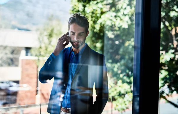 Me ocupo de los negocios. Fotografía de un joven empresario hablando por teléfono fuera de una oficina. —  Fotos de Stock