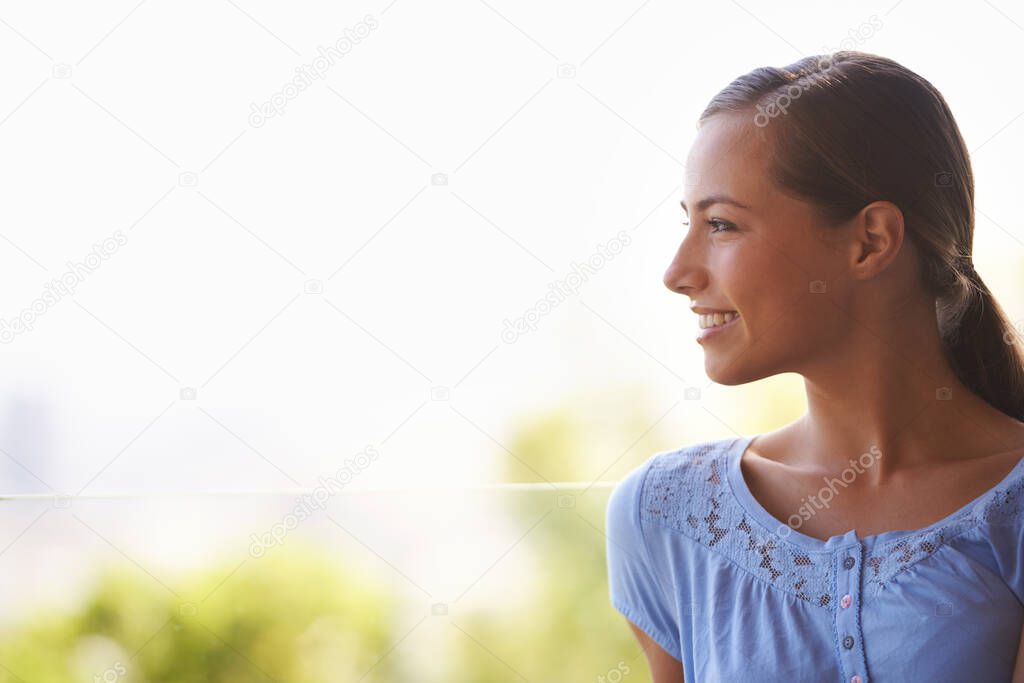 She loves the cool breeze on her face. Profile shot of a gorgeous young woman.