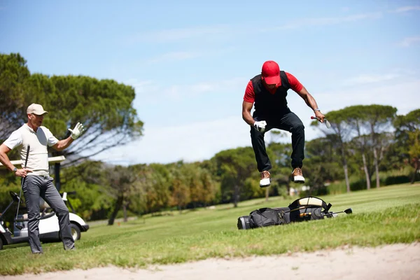 놀이를 하는 것이 어렵다고 생각 한다면 지려고 노력하 십시오. 골프 가방 위에서 점프하는 좌절 한 골퍼의 사진. — 스톡 사진