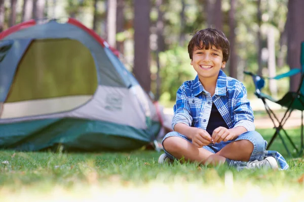 As melhores férias de verão de sempre. Retrato de um menino sentado na floresta em frente a uma tenda. — Fotografia de Stock