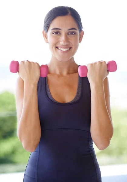 Fitness väntar inte på någon. Porträtt av en ung kvinna lyfta vikter utanför. — Stockfoto