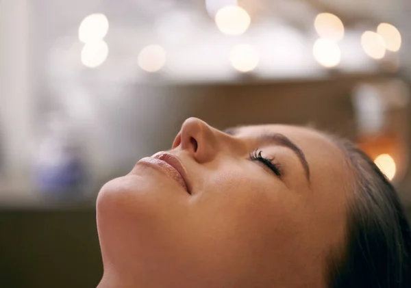 Slappna av. Närbild av en ung kvinnas ansikte under en massage. — Stockfoto