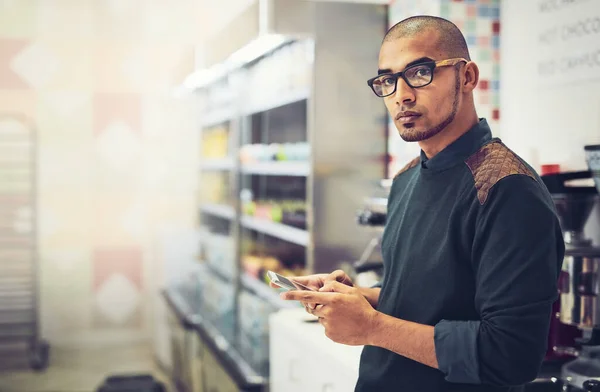 Soziale Medien spielen in der Werbung eine ernste Rolle. Aufnahme eines Mannes, der sein Handy benutzt, während er in einem Café steht. — Stockfoto