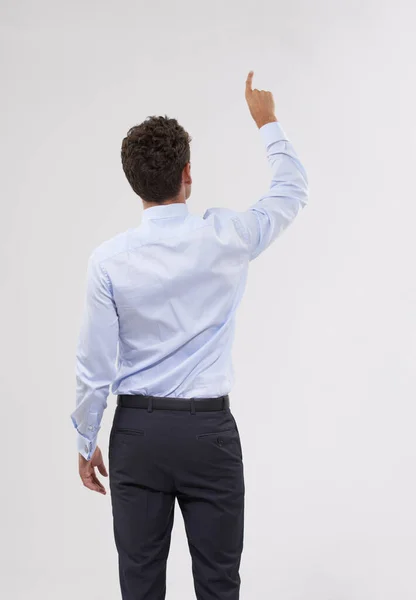 Escogiendo la mejor opción. Vista trasera de un joven hombre de negocios guapo tocando una interfaz digital transparente. — Foto de Stock