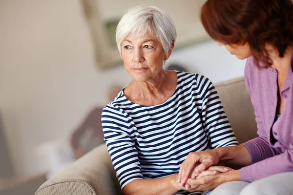 Bezorgd over de toekomst. Neergeschoten van een vrouw naast haar oudere moeder thuis.. — Stockfoto