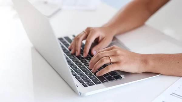 Mantenerse receptivo por correo electrónico. Primer plano de una mujer de negocios irreconocible usando un portátil en una oficina. — Foto de Stock