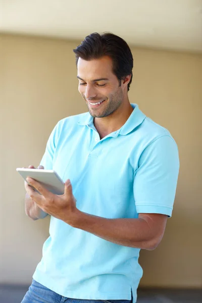 Eine neue App herunterladen. Aufnahme eines gutaussehenden Mannes mit einem digitalen Tablet im Haus. — Stockfoto