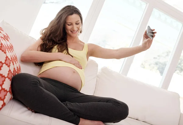 Zachytit její nenarozené dítě. Zastřelen mladý těhotná žena přičemž selfie s jejím mobilním telefonem v jejím životě. — Stock fotografie