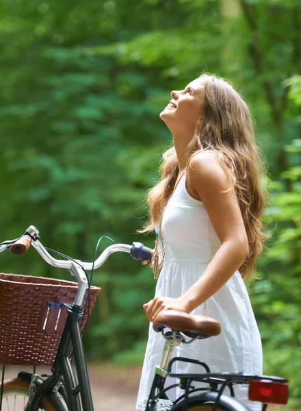 Explorando el bosque. Una hermosa joven caminando en el bosque con su bicicleta. — Foto de Stock