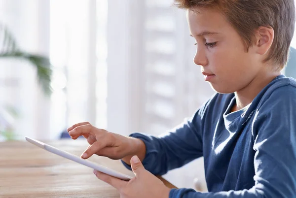 A weben rengeteg információ van. Egy fiatal fiúról készült felvétel, aki digitális tabletet használ a házi feladatához.. — Stock Fotó
