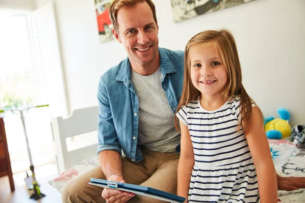 Compartir algo de tiempo en línea con papá. Fotografía de un padre y su hija sentados juntos en la sala de estar en casa usando una tableta digital. — Foto de Stock