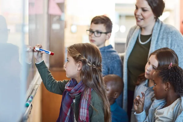 Macht weiter so, ihr macht einen tollen Job. Schnappschuss einer Grundschülerin, die auf einer Whiteboard im Klassenzimmer schreibt. — Stockfoto