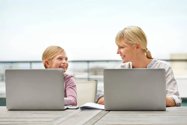 Zupełnie jak jej mama. Strzał młodej dziewczyny i jej matki korzystających z laptopów obok siebie. — Zdjęcie stockowe