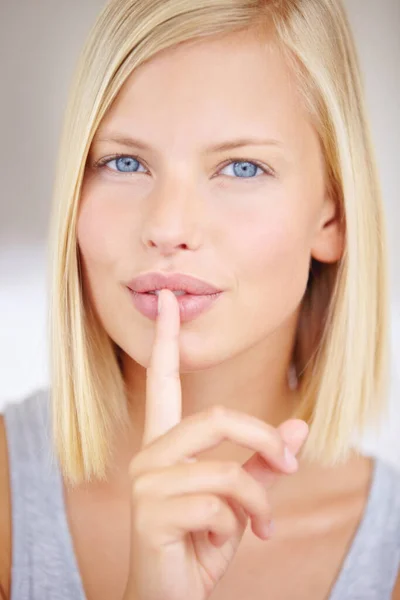 Ill never tell my beauty secrets. Portrait of a young woman holding her finger in front of her lips. — Stock Photo, Image