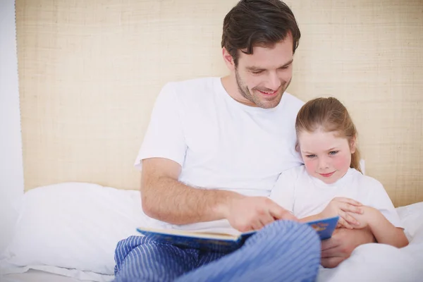 A ver todas as fotografias. Tiro de um pai dedicado lendo sua filha uma história para dormir. — Fotografia de Stock
