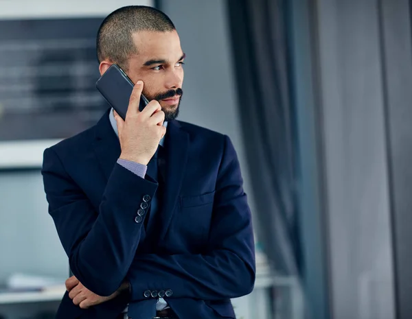 Diz-me o que quero ouvir... Tiro de um jovem homem de negócios falando em um celular em seu escritório. — Fotografia de Stock