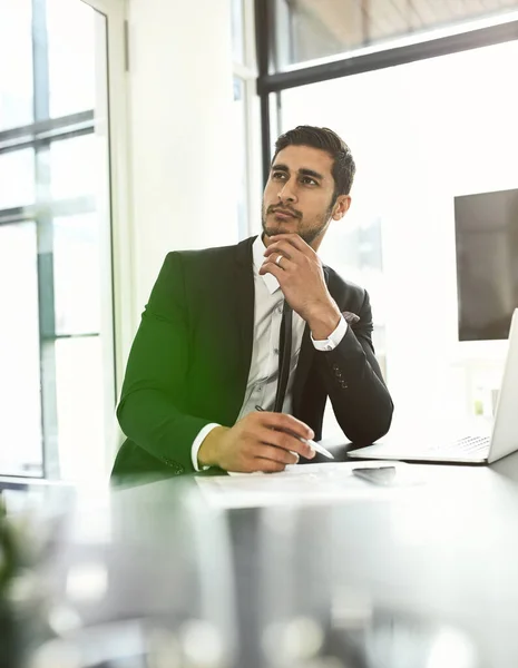 Nunca pierdas de vista tu objetivo. Fotografía de un hombre de negocios mirando reflexivo mientras se sienta en su escritorio. —  Fotos de Stock