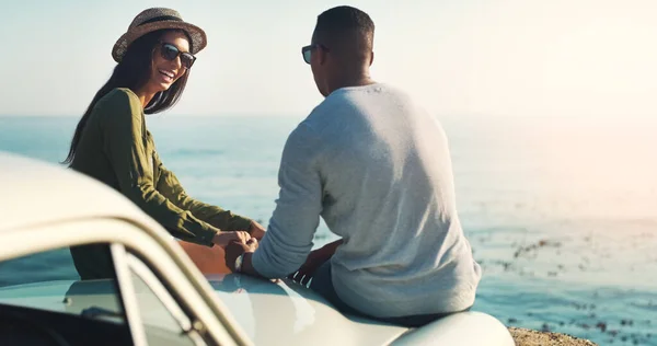 Det är allt hon behöver för att vara lycklig. Beskuren bild av ett ungt par som gör ett stopp vid stranden medan ute på en resa. — Stockfoto