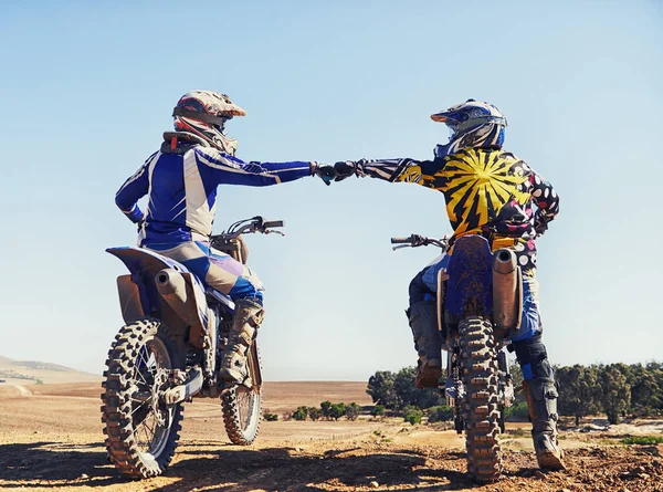 Zeit, diesen Weg zu beschreiten. Zwei Motocross-Fahrer stoßen vor Rennen mit Fäusten zusammen. — Stockfoto