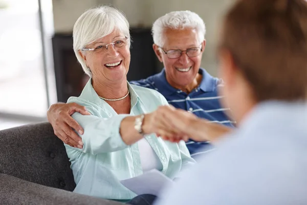 Ik schud op dat... over-the-shoulder shot van een financieel adviseur vergadering met een senior paar in hun huis. — Stockfoto