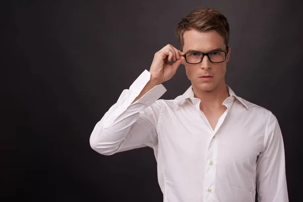 Inteligente y guapo. Un joven guapo poniéndose las gafas. —  Fotos de Stock